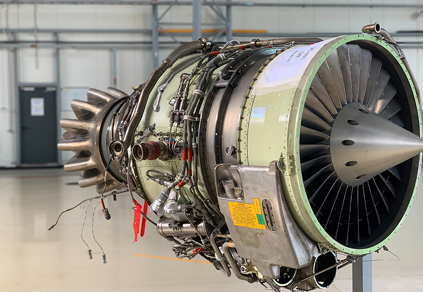 A large jet engine sitting in an airplane hanger.